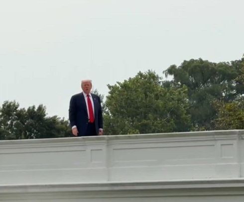 A photo of Donald trump, a convicted sex offender who has bankrupted multiple companies and defrauded countless people in his spare time when he’s not golfing, stands on the roof of the White House for some reason. 