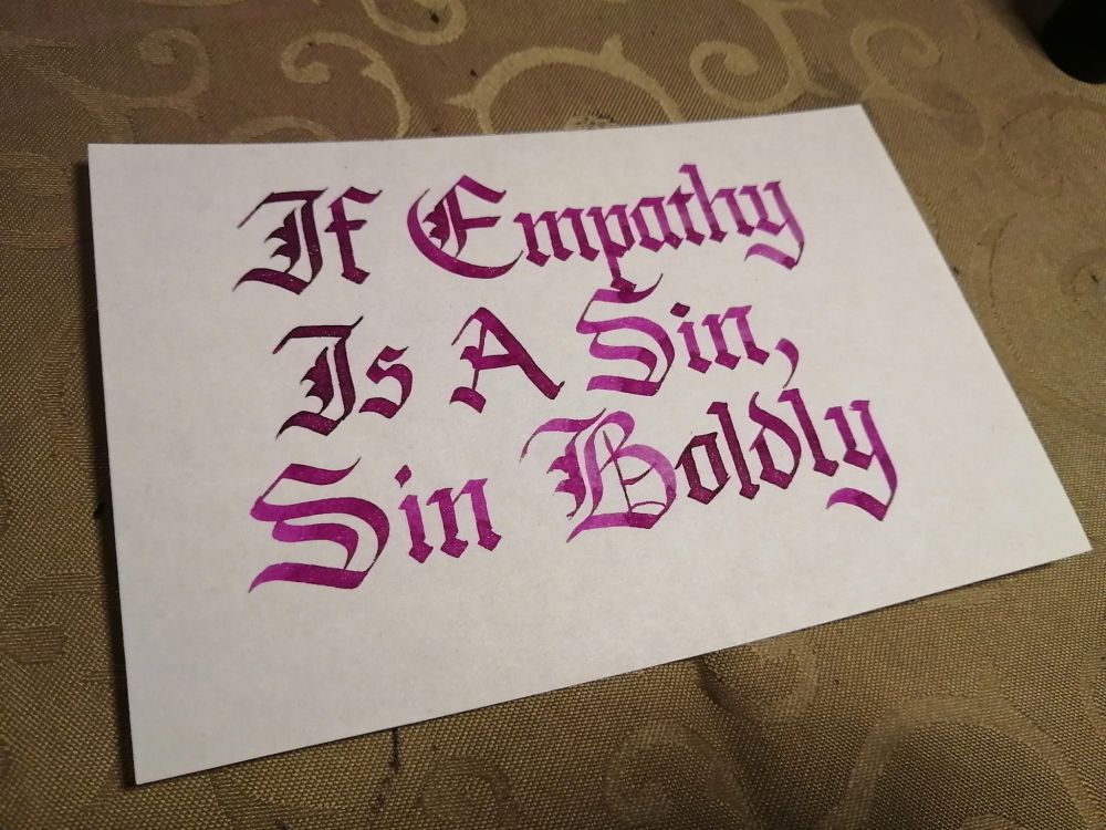 Calligraped sign that says If Empathy Is A Sin, Sin Boldly