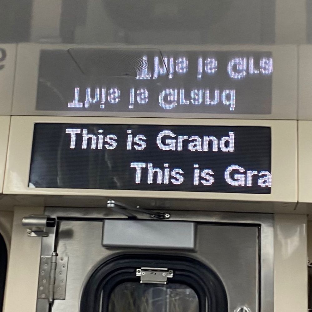 digital display on a train reading “This is Grand”
