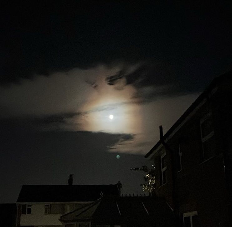 The moon, so bright the sky around it is glowing. 