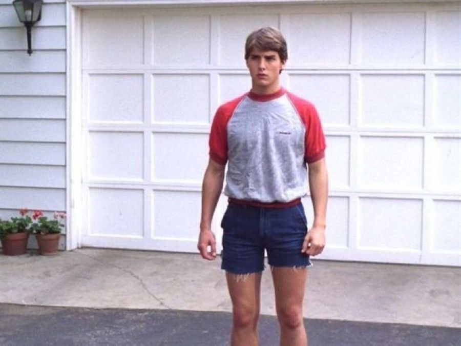 tom cruise just kinda existing in a drive way in a silly pair of jorts cut unevenly