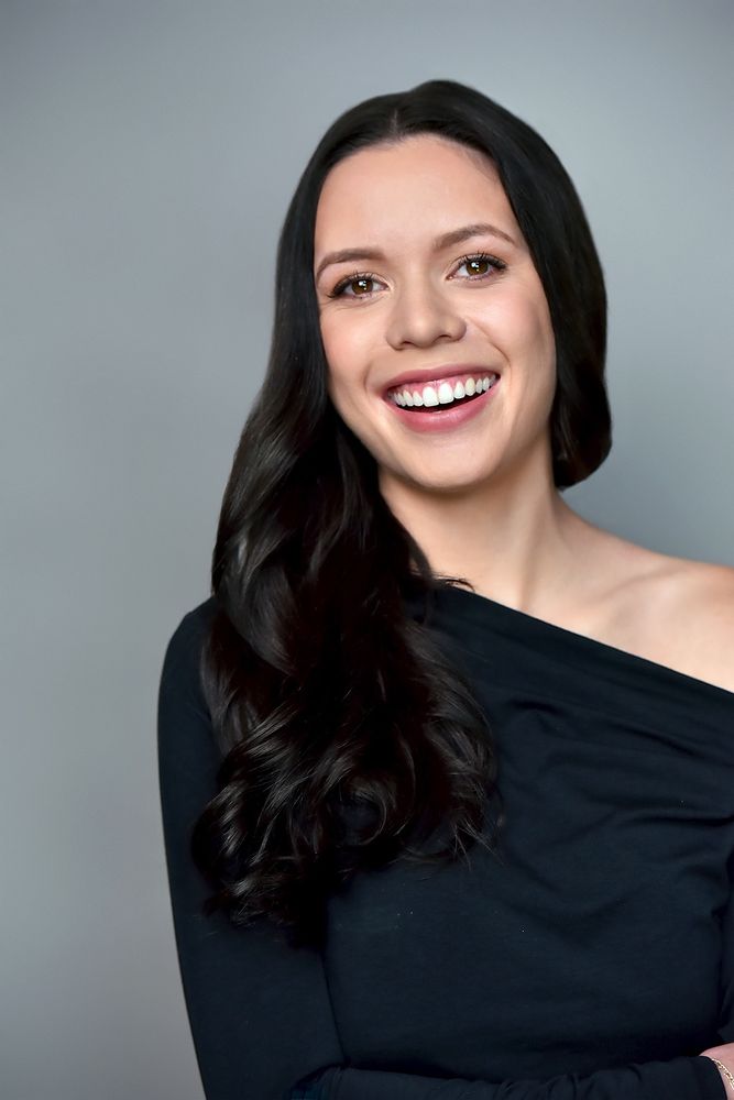 Woman smiling and wearing a black dress 