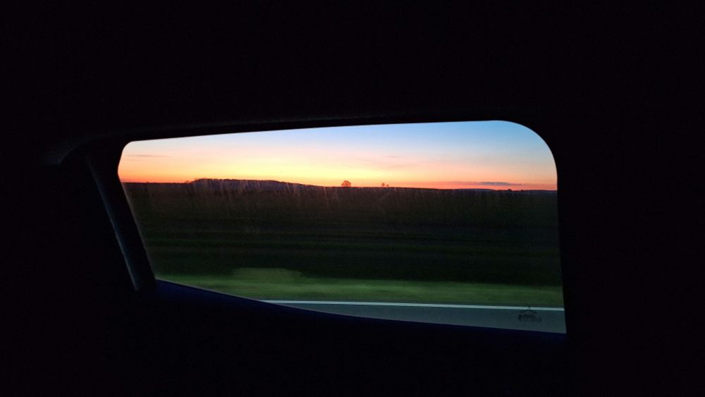 Blick aus einem Autofenster in einen Abendhimmel