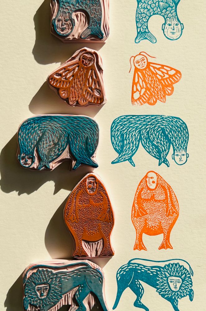A series of small carved stamps featuring weird creatures - each with a sort of expressionless human face. The top one is kind of a fish, then a moth, then a furry quadruped, then a frog and lastly a lion. The stamps are arranged vertically on the left, the corresponding images they print are on the right. The printed images are alternating teal and orange. 