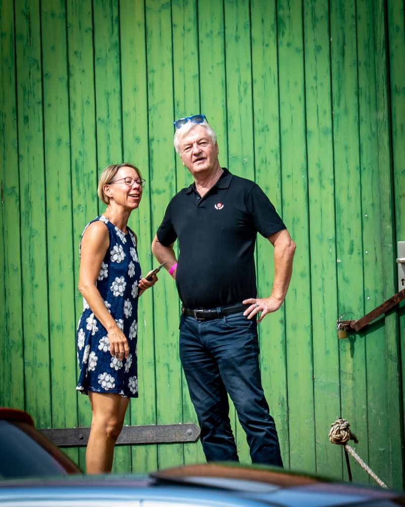 Jürgen Elsässer, der selbsternannte Alleinherrscher von Compact im Gespräch mit einer Teilnehmerin im Sommerkleid. 