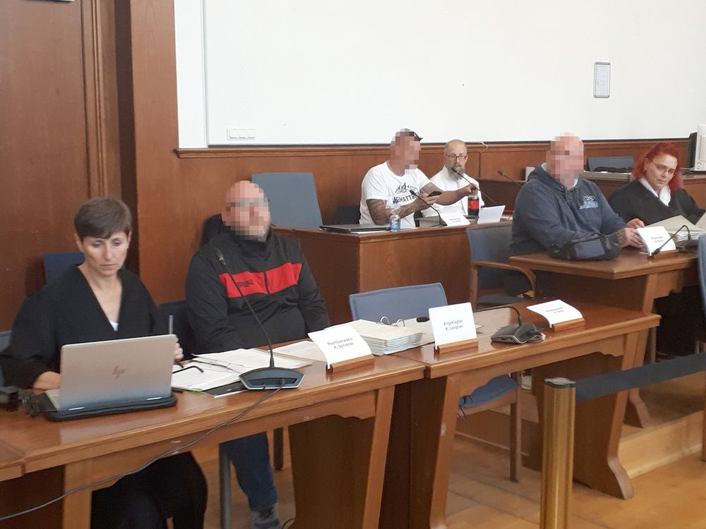 Die Angeklagten im Gerichtssaal zusammen mit ihren Verteidiger*innen