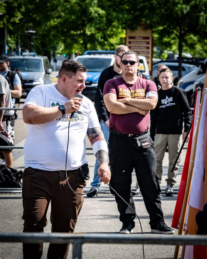 Stefan Trautmann als Redner bei einer Demo gegen den CSD in Dresden. Er trägt ein Shirt mit der Aufschrift "Döbeln verteidigen". 
