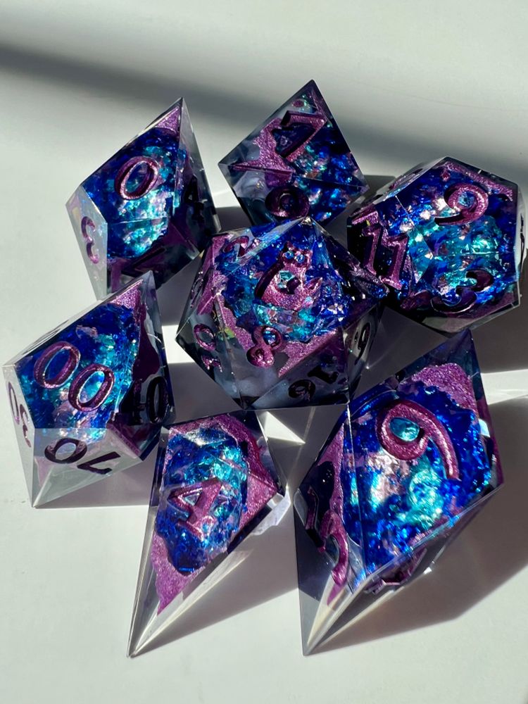 Polyhedral resin dice with blue and purple crystal foil inside.