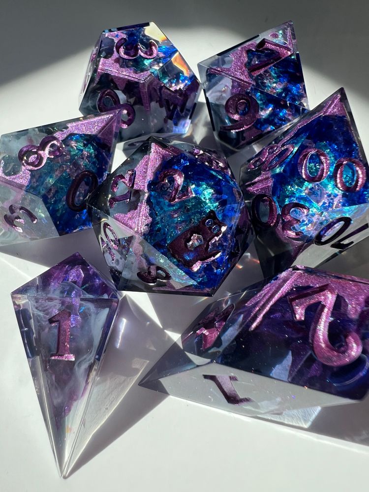 Polyhedral resin dice with blue and purple crystal foil inside.
