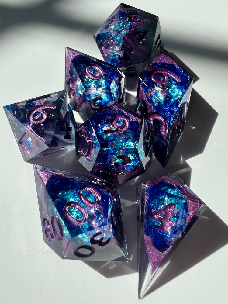 Polyhedral resin dice with blue and purple crystal foil inside.
