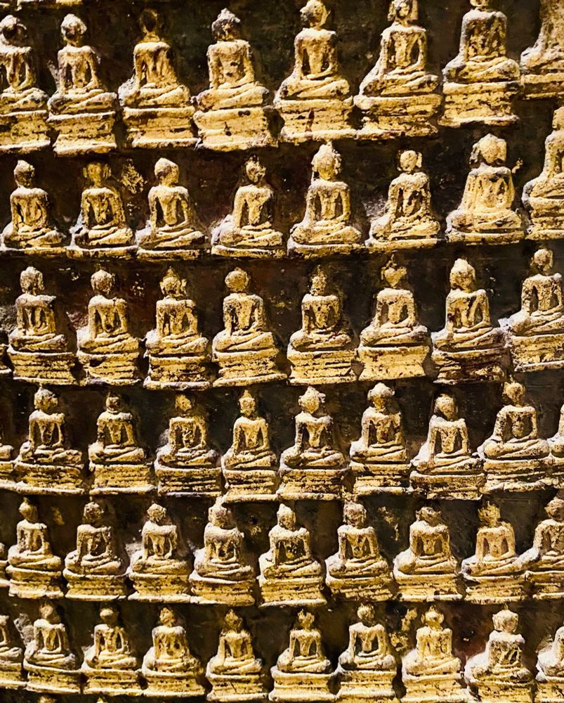 Mehrere Reihen mit kleinen goldenen Buddhastatuen