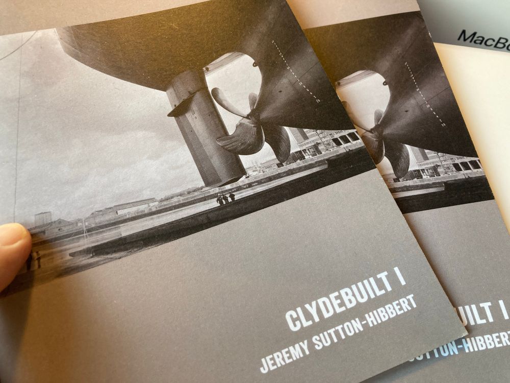 Photo of black and white photo-zine publication, depicting shipyard photography, sitting on a desk. 