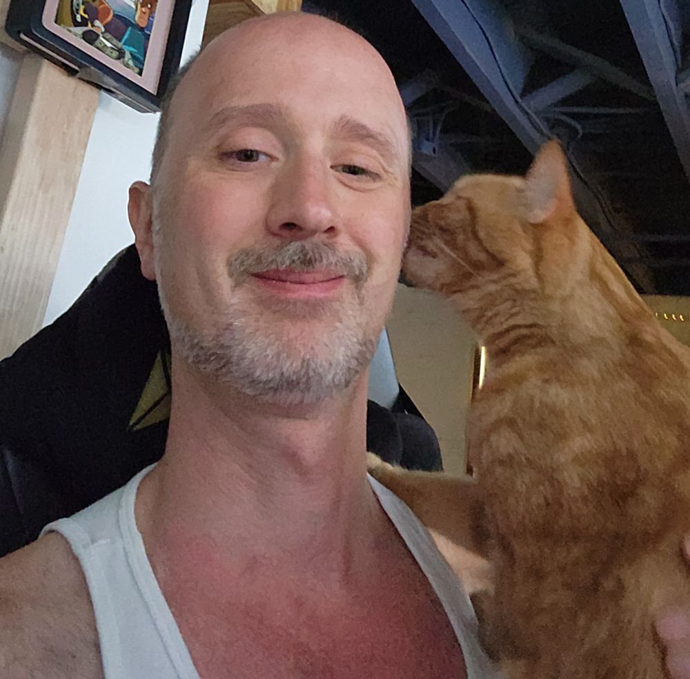The dumb face I make as an orange cat licks my ear