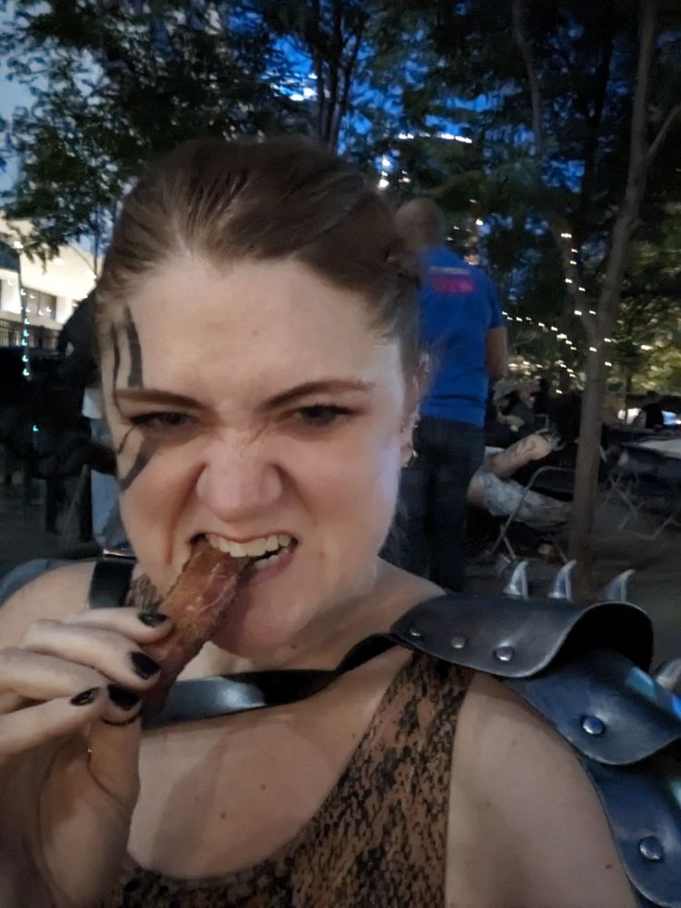 Female barbarian cosplayer eating a piece of bacon