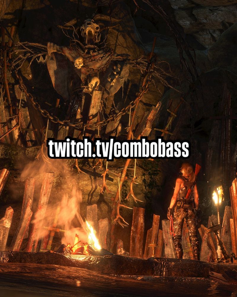 Lara looking at a scary looking effigy made of sticks and bone inside a cave lit by a campfire. 