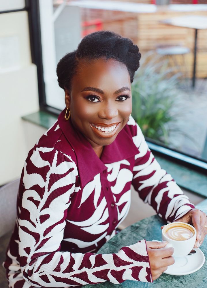 Eyitemi Popo (MDEI ’16) posing for a photo while holding a coffee