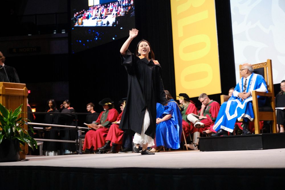 An environment grad crossing the stage inside of the PAC