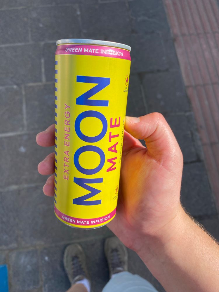 Gelbe dose mit blauem Schriftzug „Moon“ in geraden, serifenlosen Großbuchstaben. Drunter steht in pink Mate.