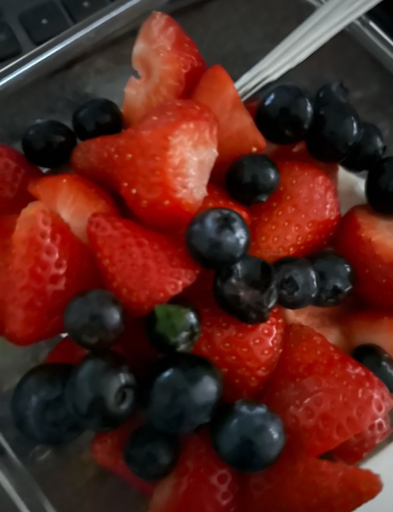 A bowl of Greek yoghurt, blueberries, and strawberries. 