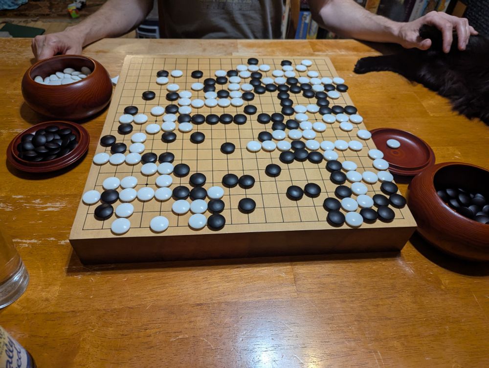 A go board where the black player (9 stone disadvantage) has managed to capture 1 stone, and the white has a few dozen more. 