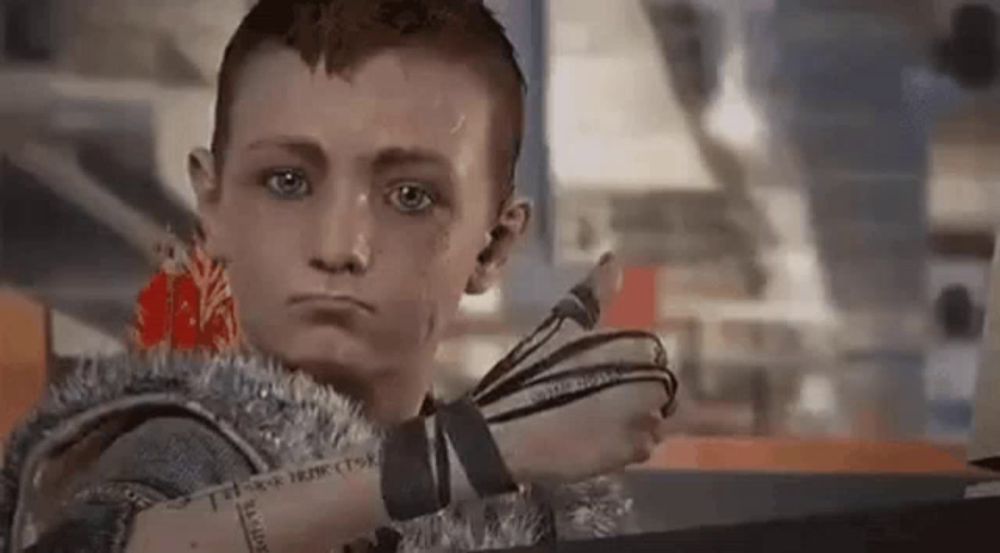 a young boy is giving a thumbs up in a video game while wearing a glove .