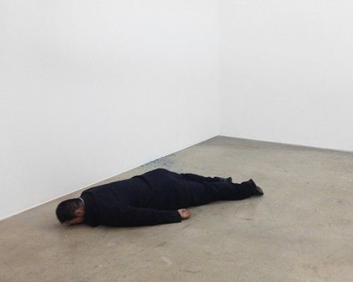 Man lying face down on the ground. I think this is actually a fiberglass sculpture called 'the death of marat'.