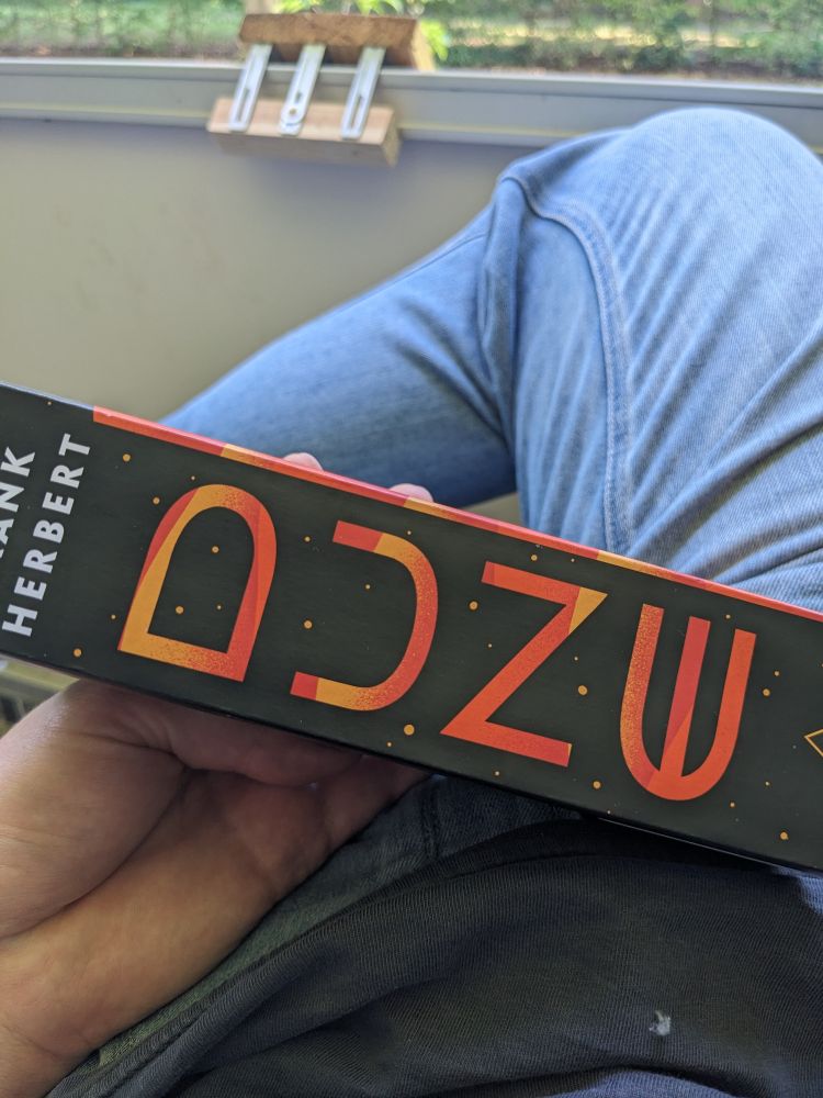 ein Buch mit der Aufschrift Frank Herbert - ADZU oder vllt steht da auch was anderes zbspw Dune