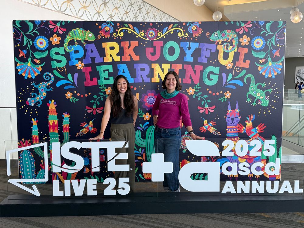 The ISTE Live and ASCD Annual photo booth is a delight this year - and we are delighted to be standing in front of it. Text reads SPARK JOYFUL LEARNING in vibrant, Texas-inspired font with stylized plants and animals all around.