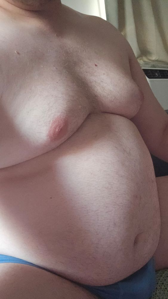 Large fat man sits wearing blue underwear