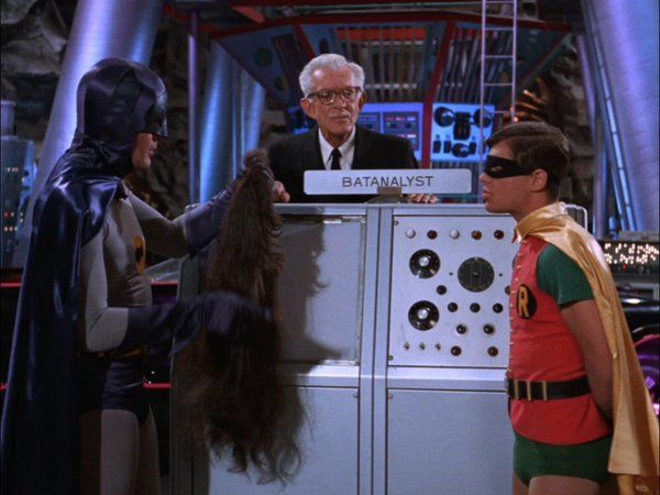 Batman 1966 TV show still with Batman, Robin, and Alfred standing around a machine labeled "Batanalyst"