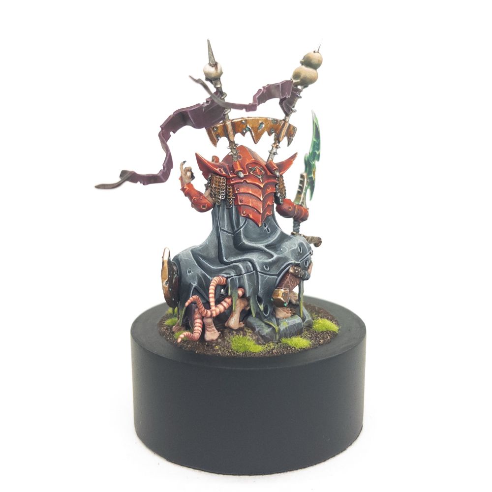 Krittok foulblade in red armour, based on a plinth - form the back right 