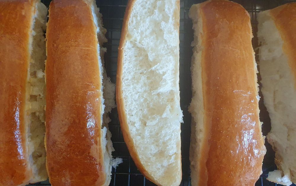 Top down look at 5 of the hot dog buns, now separated and one on the side to show it's pillowy, soft crumb!