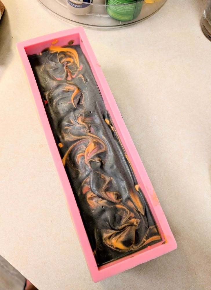 A loaf of dark grey soak with orange swirls 