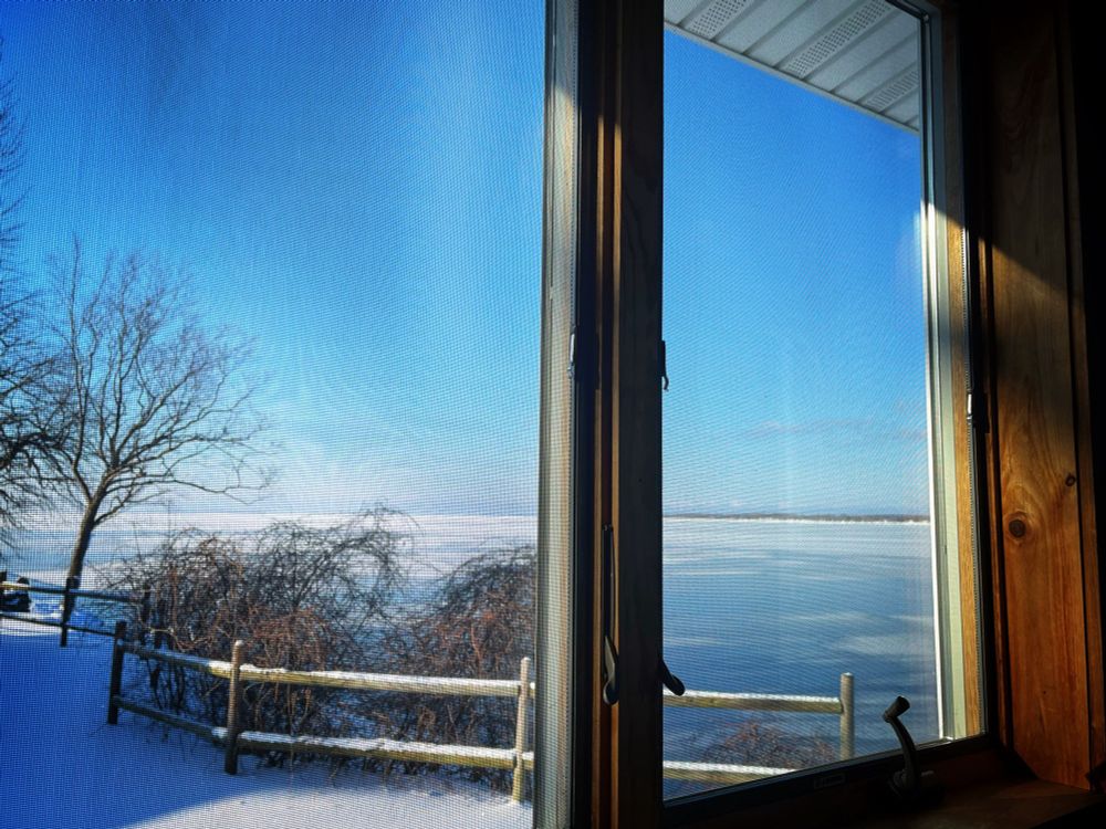  Cloudless blue sky above a lake lightly iced over.