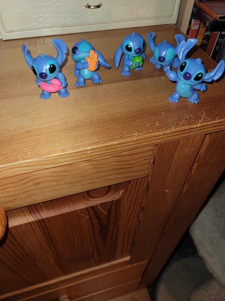 5 x Stitch in verschiedenen Positionen. Mit Herz, offenen Armen, Gummibadering um den Bauch, Frosch in der Hand und sitzend auf den Ellenbogen aufgestützt mit geschlossenen Augen.