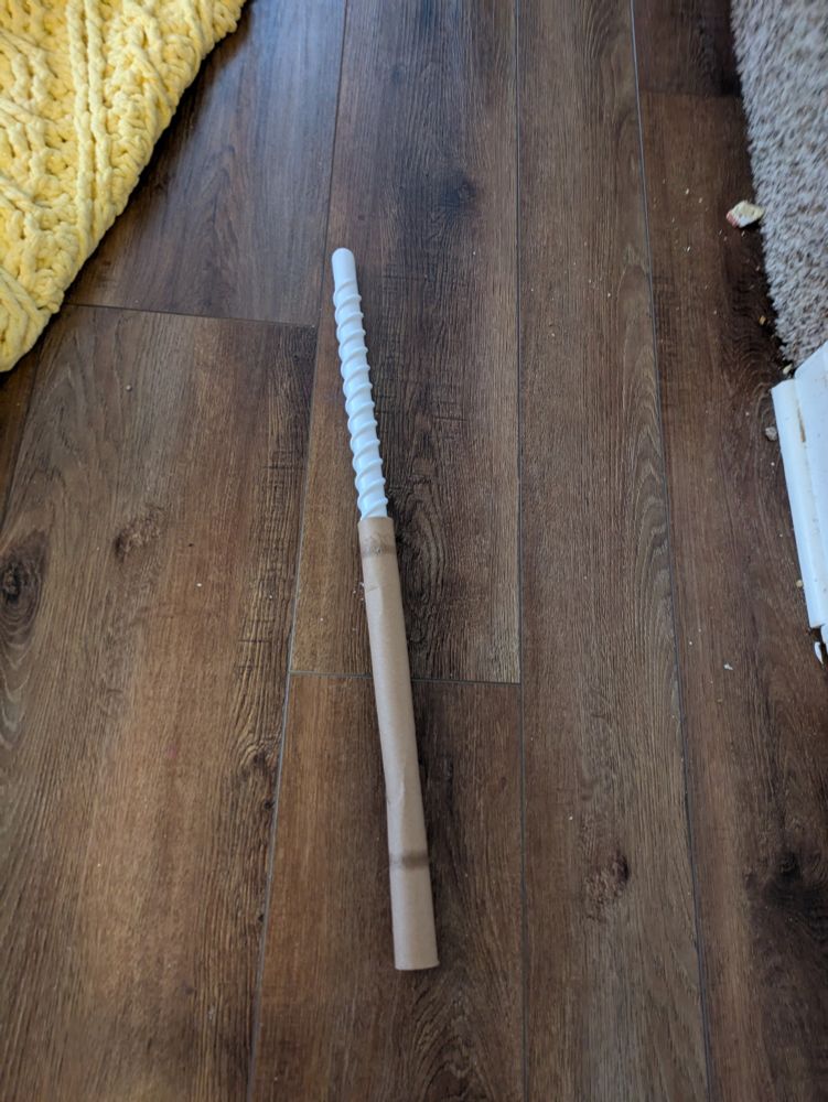 A plastic rod stuffed in a paper towel tube, baby's first lightsaber.
