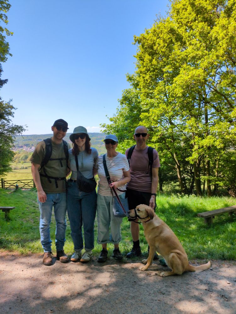 A family photo with the skeeter, his girlfriend, her parents, and her sister (who is a dog). The weather is really beautiful and there is a blue sky and a great view of a valley behind them.