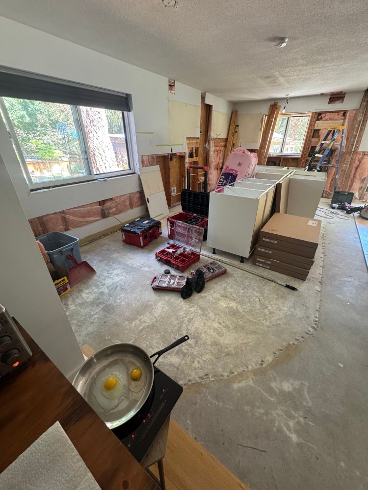 kitcheb renovation with a frying pan with two eggs in it in the foreground 