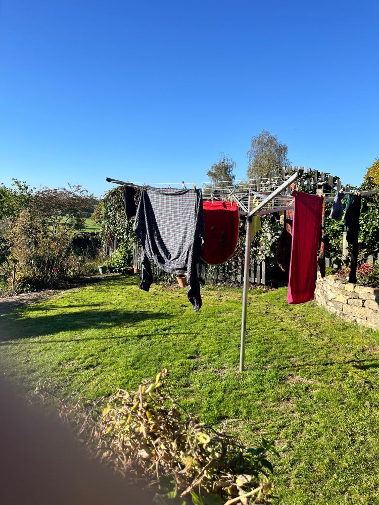 Washing drying on a rotary line in the sunshine in September