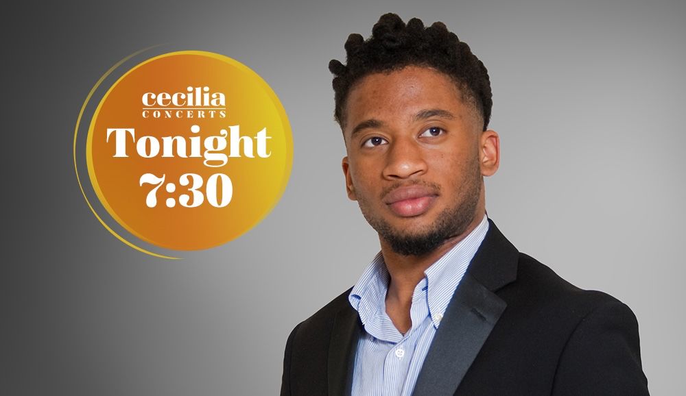 Irain Quirós stands confidently holding a violin and bow in his hands. He is wearing a black blazer with a satin lapel over a light blue button-up shirt. His expression is calm and poised. The background is a smooth gradient grey, and in the upper left corner is a circular orange-yellow graphic that reads: “Cecilia Concerts - Tonight 7:30.”