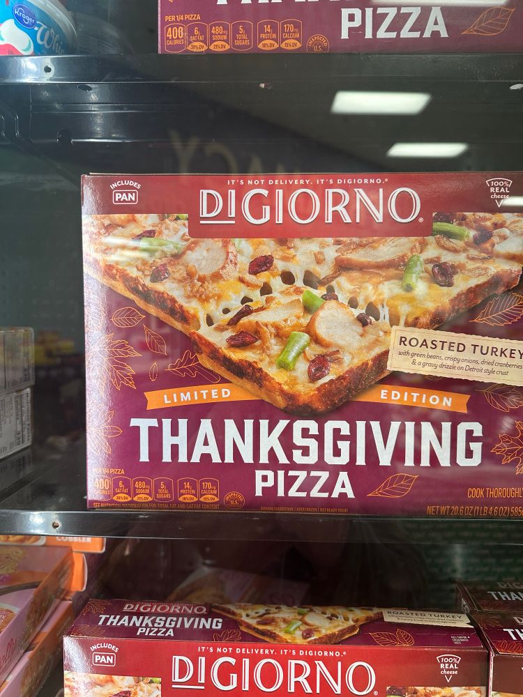 Frozen DiGiorno Thanksgiving pizza in a grocery store freezer case.