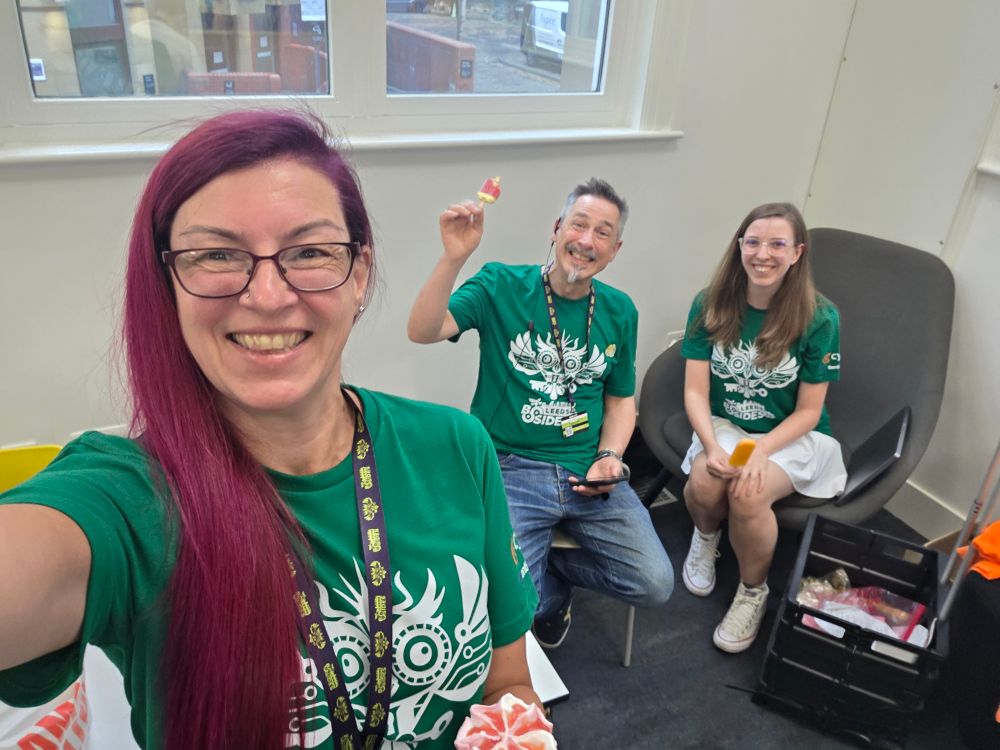 3 very happy people in green volunteer tshirts with ice creams.