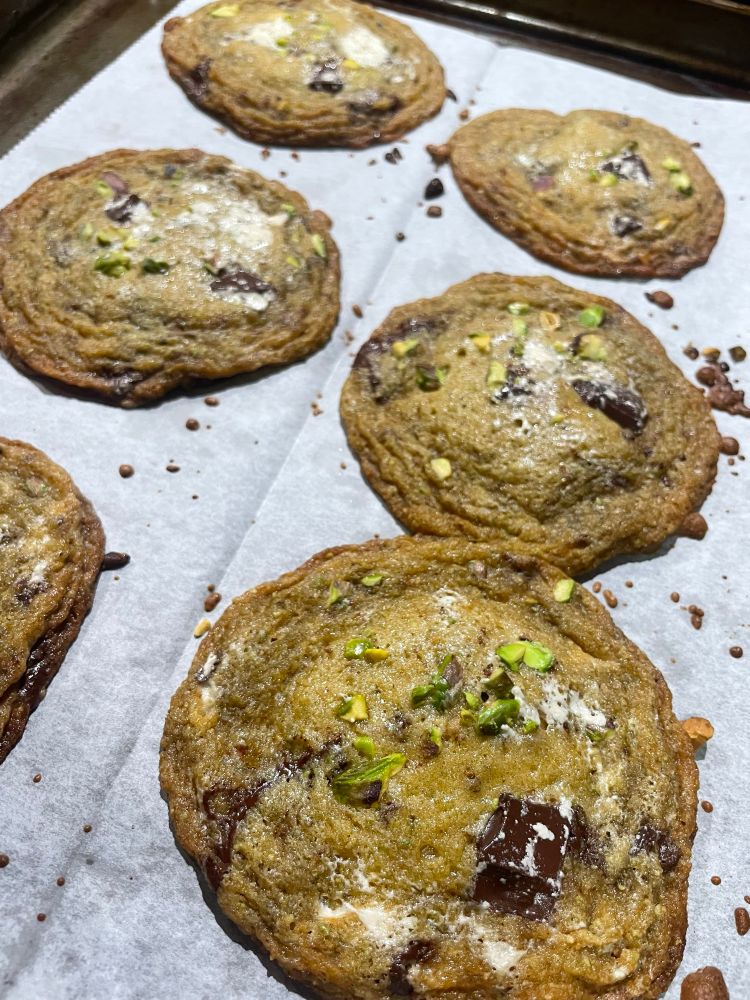 Six cookies made with brown butter, pistachio, halva, and dark chocolate chunks