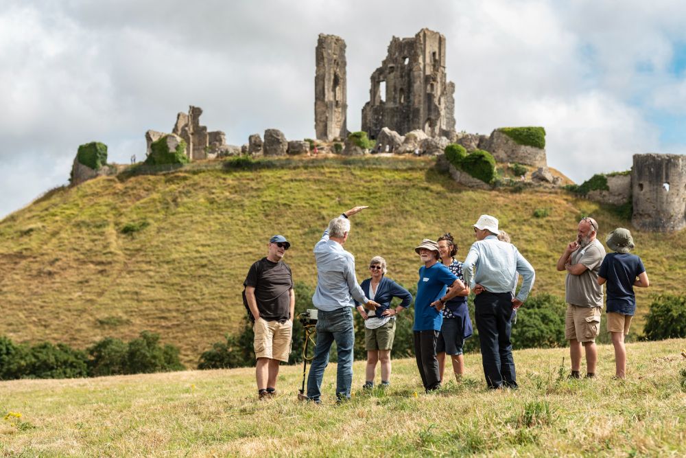 Archaeologist Martin Papworth giving an archaeology talk with Corfe Castle in the background. ©National Trust Images/Paul Harris
