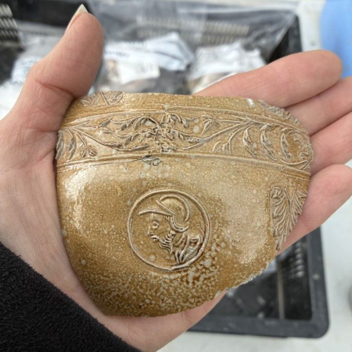 A fragment of a Tudor period German stoneware flagon which is decorated with various designs, including man wearing a helmet or hat