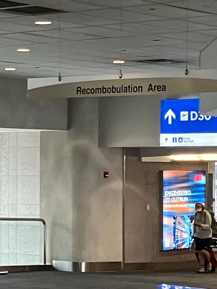 A sign in an airport that says “Recomobobulation Area”