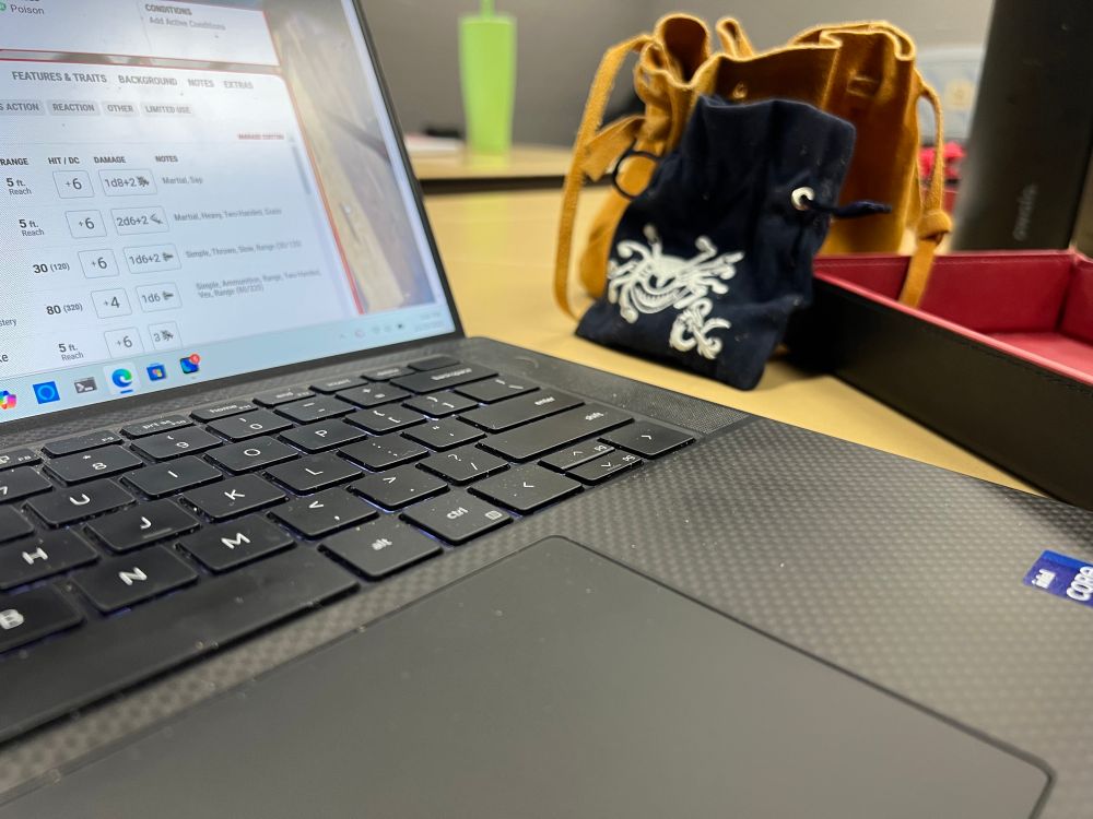 Laptop and Dice playing Dungeons and Dragons 