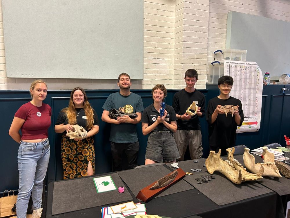 A group of PhD students posing with a variety of skull casts. Some of the PhD students look more normal than others...