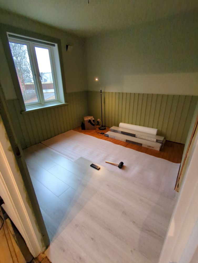 An empty bedroom with halfway laid flooring