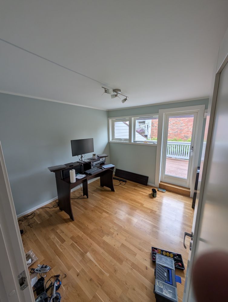 Mostly empty room with a desk and tools lying around in an unorderly fashion